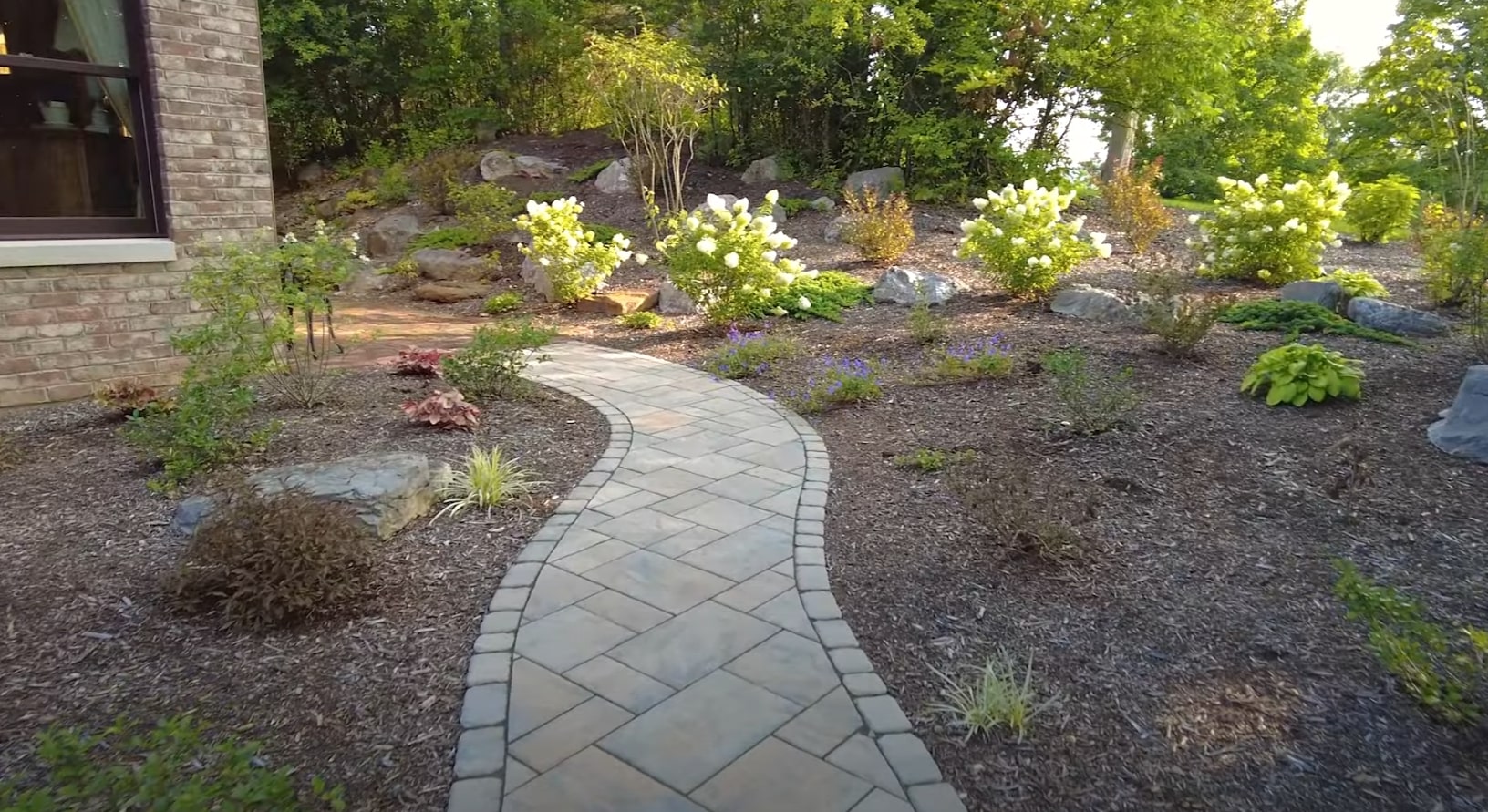 Professional hardscape design with natural stone pathways and native plant landscaping