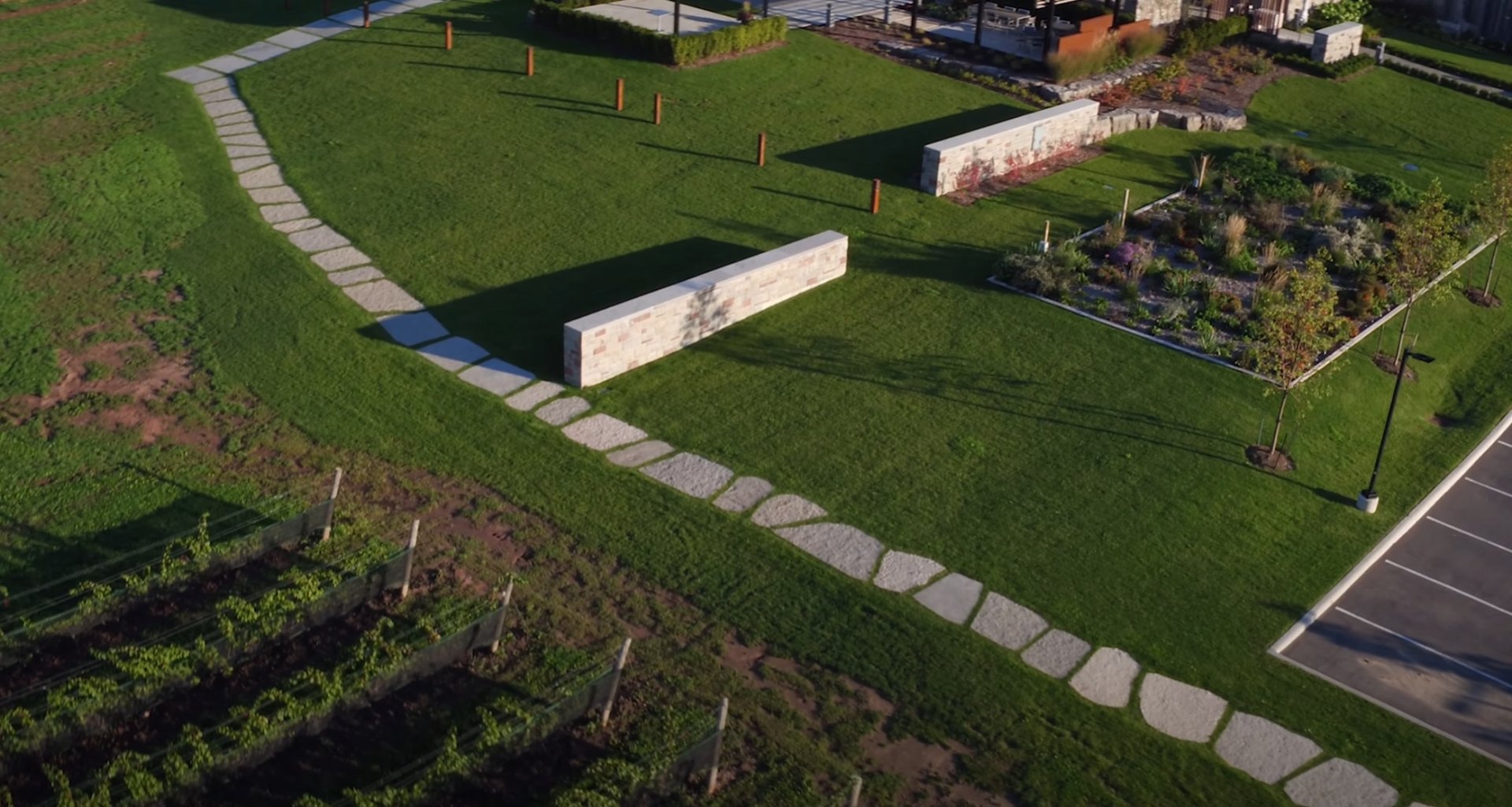 Aerial landscape design featuring curved stone pathways, geometric lawn patterns, and modern hardscaping elements